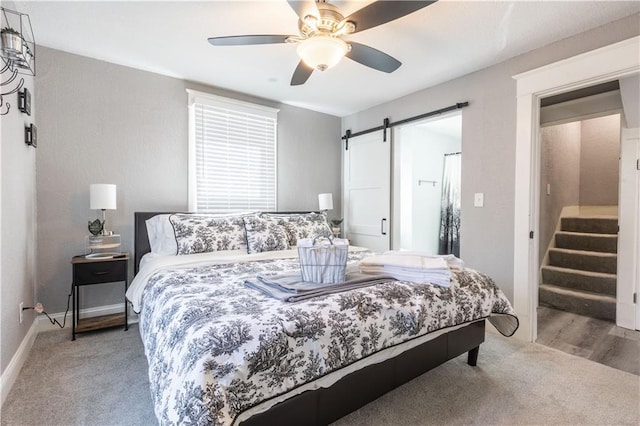 3221 E 11th St, Kansas City, MO 64127 - carpeted bedroom with a barn door and a ceiling fan