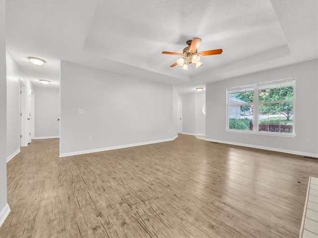 1914 S Leslie Dr, Independence, MO 64055 - unfurnished room with a raised ceiling, a ceiling fan, and wood finished floors