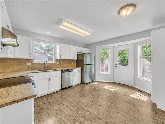 1914 S Leslie Dr, Independence, MO 64055 - kitchen with stainless steel appliances, wall chimney range hood, a textured ceiling, and white cabinetry