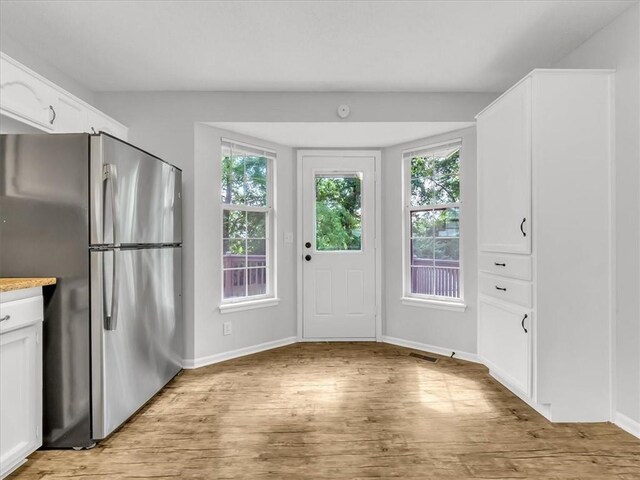 1914 S Leslie Dr, Independence, MO 64055 - kitchen with freestanding refrigerator, light wood-type flooring, white cabinetry, and light countertops