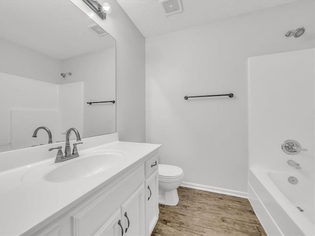 1914 S Leslie Dr, Independence, MO 64055 - full bathroom with vanity, wood finished floors, bathing tub / shower combination, and a textured ceiling