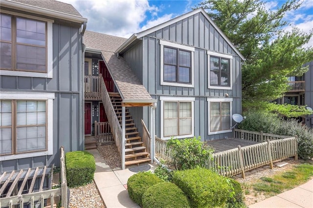 12818 W 110th Ter, Overland Park, KS 66210 - view of front of house with board and batten siding, a shingled roof, and stairway