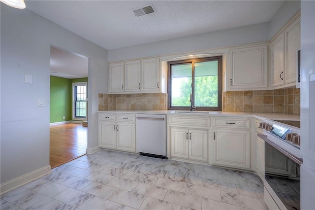 12818 W 110th Ter, Overland Park, KS 66210 - kitchen with white dishwasher, stove, light countertops, light marble finish floors, and decorative backsplash