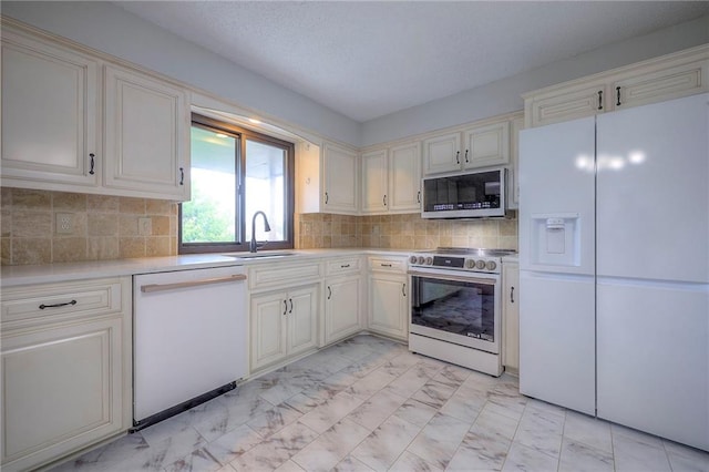12818 W 110th Ter, Overland Park, KS 66210 - kitchen featuring appliances with stainless steel finishes, light marble finish floors, light countertops, and backsplash