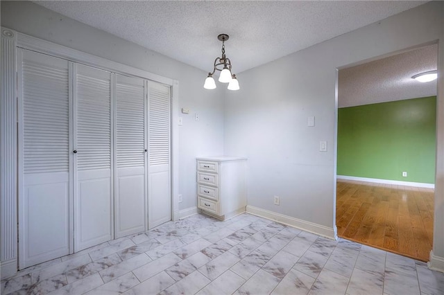 12818 W 110th Ter, Overland Park, KS 66210 - unfurnished dining area featuring light marble finish floors, a textured ceiling, and a chandelier