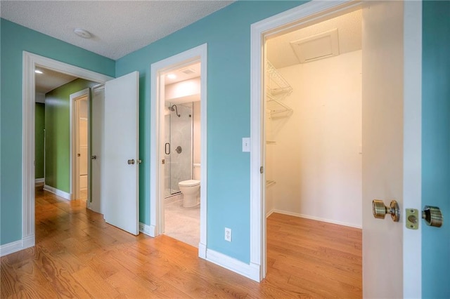 12818 W 110th Ter, Overland Park, KS 66210 - unfurnished bedroom featuring light wood finished floors, a walk in closet, attic access, connected bathroom, and a closet