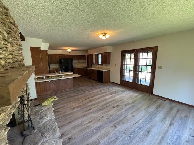 603 Lakeside Ct, Girard, KS 66743 - kitchen with freestanding refrigerator, a textured ceiling, wood finished floors, french doors, and light countertops