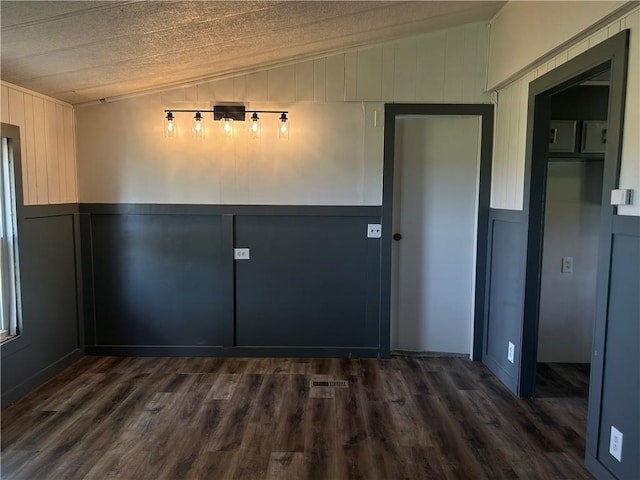 2587 Crk 2200, Caney, KS 67333 - unfurnished dining area with vaulted ceiling, dark wood-style floors, and a decorative wall