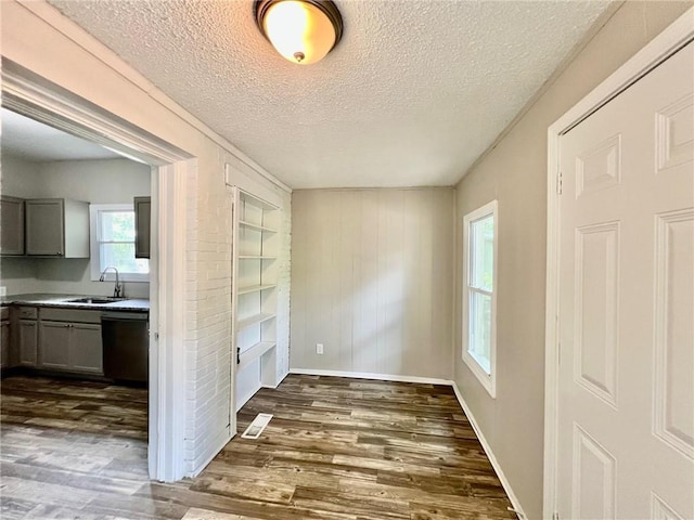 537 S Brookside Ave, Independence, MO 64053 - unfurnished dining area with a textured ceiling, dark wood-style flooring, and built in shelves