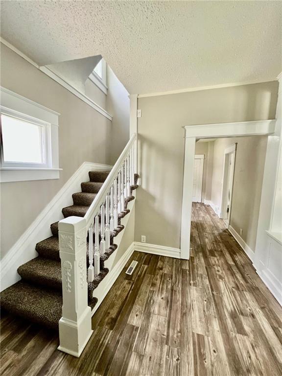 537 S Brookside Ave, Independence, MO 64053 - stairs featuring a textured ceiling and wood finished floors