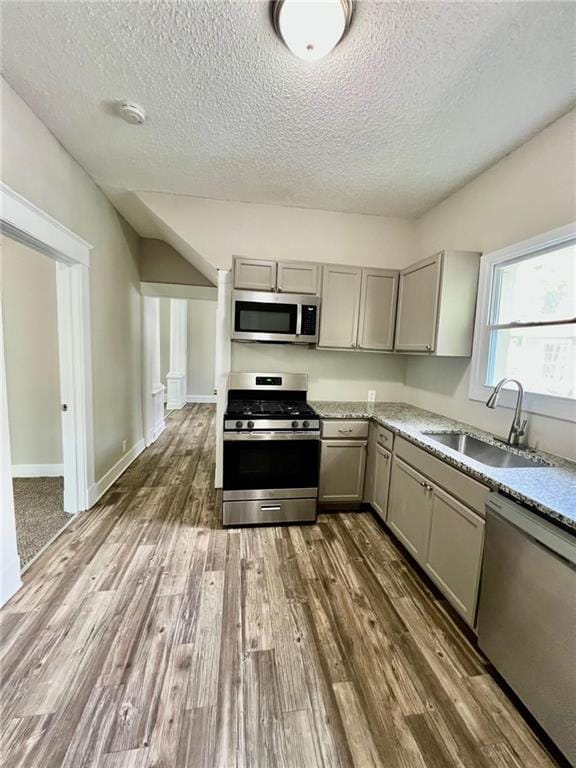 537 S Brookside Ave, Independence, MO 64053 - kitchen featuring stainless steel appliances, gray cabinets, a textured ceiling, dark wood finished floors, and light stone counters