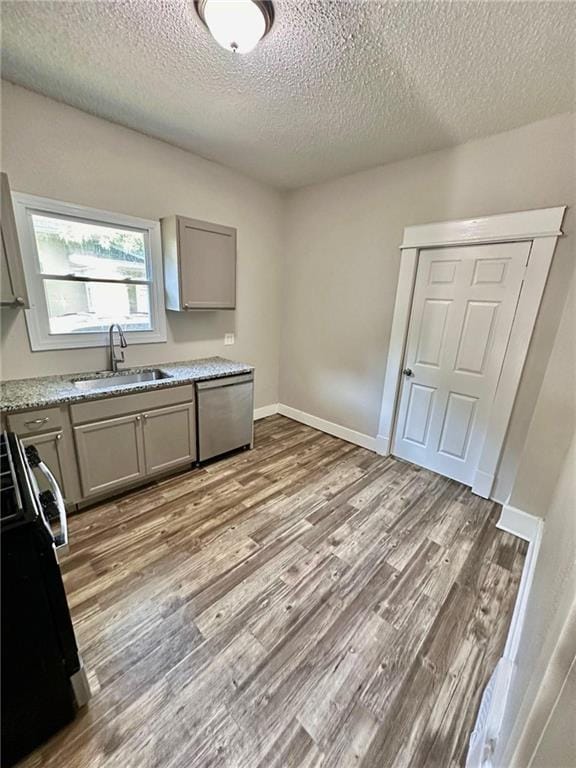 537 S Brookside Ave, Independence, MO 64053 - kitchen featuring stainless steel dishwasher, stove, gray cabinets, wood finished floors, and a textured ceiling