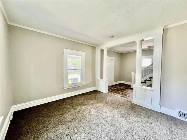 537 S Brookside Ave, Independence, MO 64053 - empty room featuring dark colored carpet, ornate columns, crown molding, stairs, and a textured ceiling