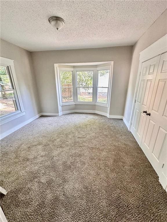 537 S Brookside Ave, Independence, MO 64053 - unfurnished bedroom with carpet floors, a textured ceiling, and a closet