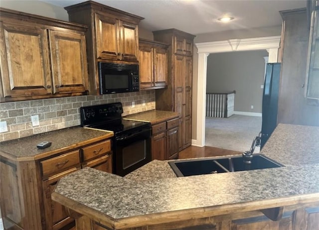1703 Esther Dr, Kearney, MO 64060 - kitchen with black appliances, backsplash, brown cabinets, dark countertops, and recessed lighting