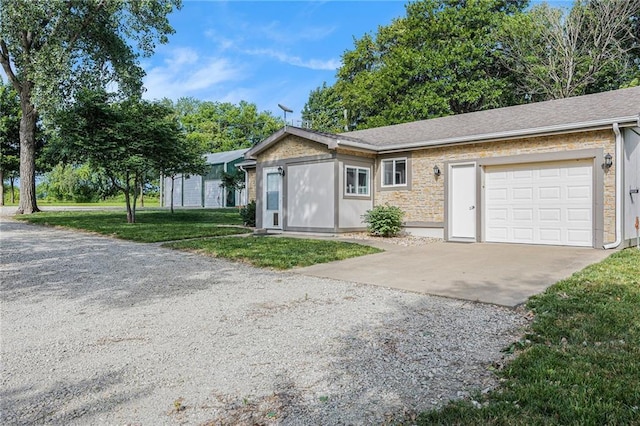 1433 Haskell Rd, Williamsburg, KS 66095 - single story home with driveway, an attached garage, a front lawn, and stone siding