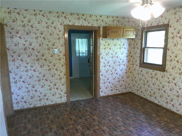 1022 Sycamore St, Humboldt, KS 66748 - unfurnished room featuring wallpapered walls, brick patterned floors, and ceiling fan