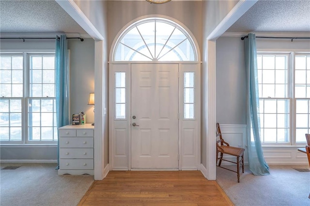 11580 S Skyview Ln, Olathe, KS 66061 - entryway with a textured ceiling, wood finished floors, and wainscoting