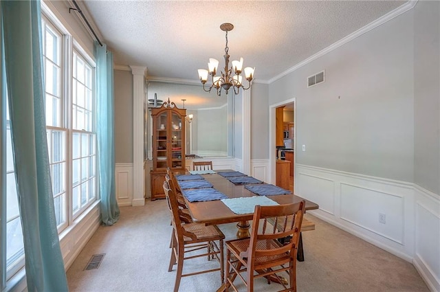 11580 S Skyview Ln, Olathe, KS 66061 - dining space with healthy amount of natural light, a decorative wall, a chandelier, light colored carpet, and a wainscoted wall