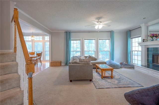 11580 S Skyview Ln, Olathe, KS 66061 - living room featuring carpet, a ceiling fan, a textured ceiling, a tile fireplace, and ornamental molding