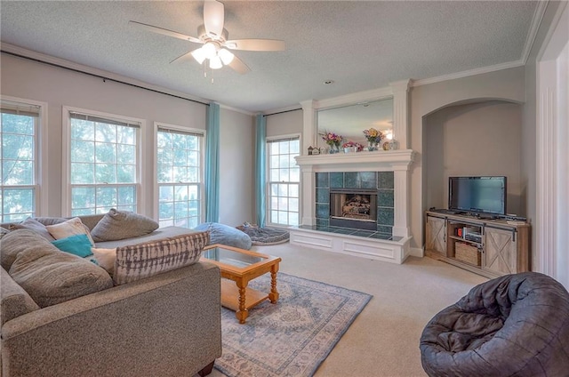 11580 S Skyview Ln, Olathe, KS 66061 - living room featuring a textured ceiling, ornamental molding, a ceiling fan, a tiled fireplace, and carpet