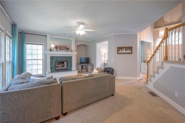 11580 S Skyview Ln, Olathe, KS 66061 - living room featuring a fireplace, light colored carpet, a ceiling fan, a textured ceiling, and stairway