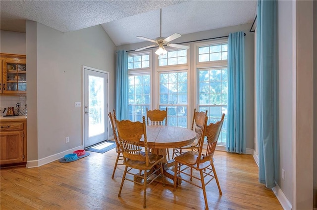 11580 S Skyview Ln, Olathe, KS 66061 - dining area with a ceiling fan, a textured ceiling, healthy amount of natural light, light wood finished floors, and vaulted ceiling