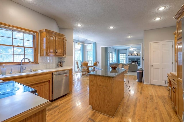 11580 S Skyview Ln, Olathe, KS 66061 - kitchen with dishwasher, a textured ceiling, a ceiling fan, a center island, and backsplash