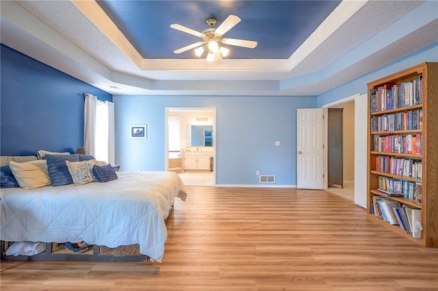 11580 S Skyview Ln, Olathe, KS 66061 - bedroom with a raised ceiling, light wood-style floors, ensuite bathroom, and a ceiling fan