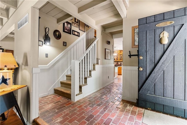 200 NE Oak Tree Cir, Lees Summit, MO 64086 - entryway featuring stairway, a wainscoted wall, brick floors, and beamed ceiling