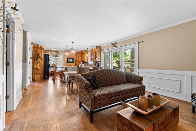 200 NE Oak Tree Cir, Lees Summit, MO 64086 - living area with crown molding, plenty of natural light, a decorative wall, light wood-style flooring, and wainscoting