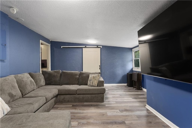 2716 S 52nd St, Kansas City, KS 66106 - living area with a barn door, a textured ceiling, and wood finished floors