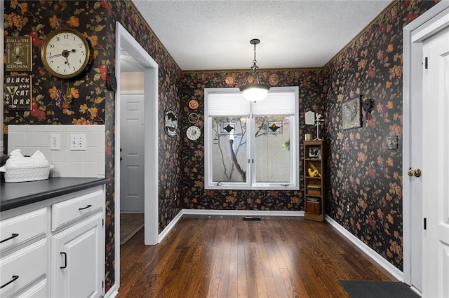 5817 Park Cir, Shawnee, KS 66216 - unfurnished dining area featuring wallpapered walls, dark wood-style flooring, and a textured ceiling