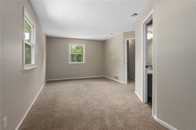 7421 NW 76th Ter, Kansas City, MO 64152 - unfurnished room featuring a textured ceiling, carpet flooring, and a textured wall