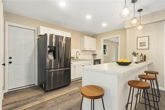 7421 NW 76th Ter, Kansas City, MO 64152 - kitchen featuring stainless steel fridge with ice dispenser, a kitchen bar, dark wood-style floors, and recessed lighting