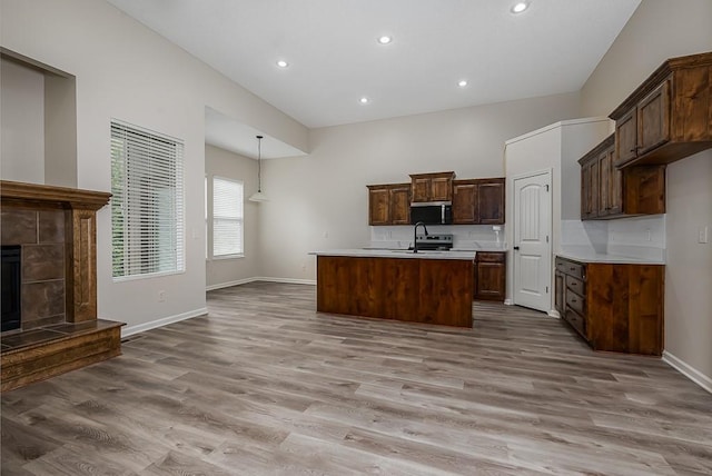 20444 W 125th Ter, Olathe, KS 66061 - kitchen with light countertops, stainless steel microwave, light wood finished floors, a kitchen island with sink, and recessed lighting