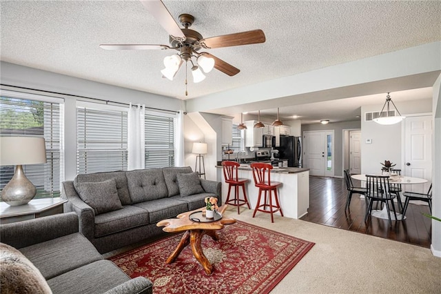 9583 N Main St, Kansas City, MO 64155 - living area featuring a ceiling fan, a textured ceiling, and dark colored carpet