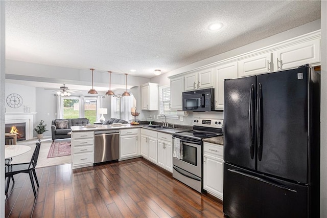 9583 N Main St, Kansas City, MO 64155 - kitchen with black appliances, open floor plan, dark countertops, a textured ceiling, and white cabinets