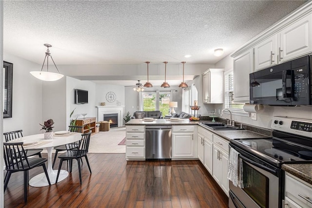 9583 N Main St, Kansas City, MO 64155 - kitchen with stainless steel appliances, white cabinetry, open floor plan, a textured ceiling, and dark countertops