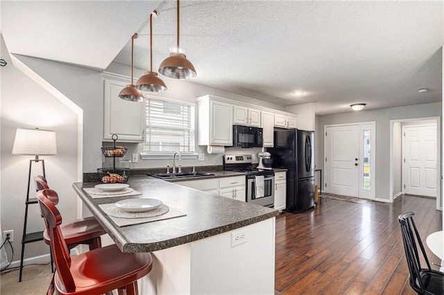 9583 N Main St, Kansas City, MO 64155 - kitchen featuring black appliances, dark countertops, a kitchen breakfast bar, white cabinetry, and a peninsula