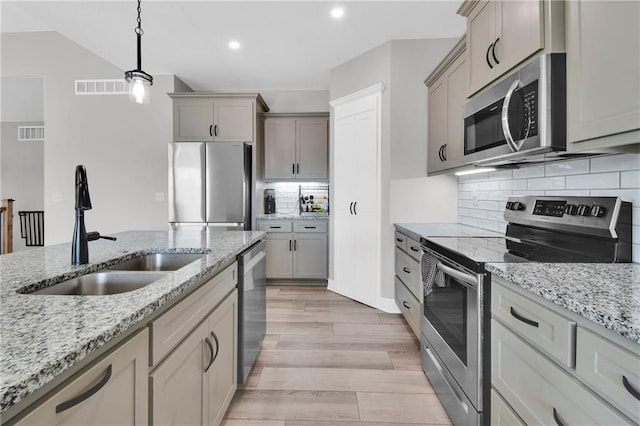 307 S Wilson St, Archie, MO 64725 - kitchen with stainless steel appliances, decorative light fixtures, light wood-type flooring, backsplash, and recessed lighting