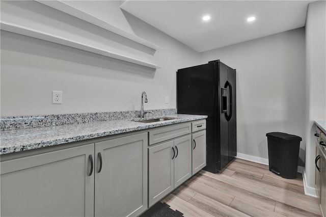 307 S Wilson St, Archie, MO 64725 - kitchen featuring light wood-style flooring, recessed lighting, gray cabinets, light stone counters, and black refrigerator with ice dispenser