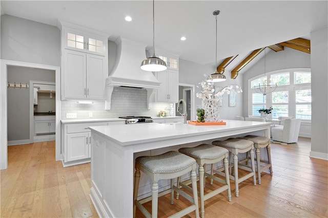 2210 W 73rd St, Prairie Village, KS 66208 - kitchen featuring premium range hood, backsplash, light countertops, white cabinets, and a chandelier