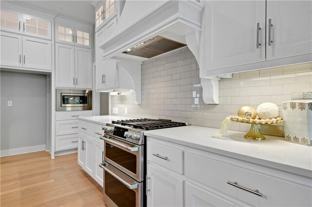 2210 W 73rd St, Prairie Village, KS 66208 - kitchen with appliances with stainless steel finishes, custom exhaust hood, light countertops, and white cabinets