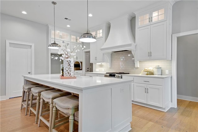 2210 W 73rd St, Prairie Village, KS 66208 - kitchen with custom exhaust hood, light countertops, white cabinetry, and recessed lighting