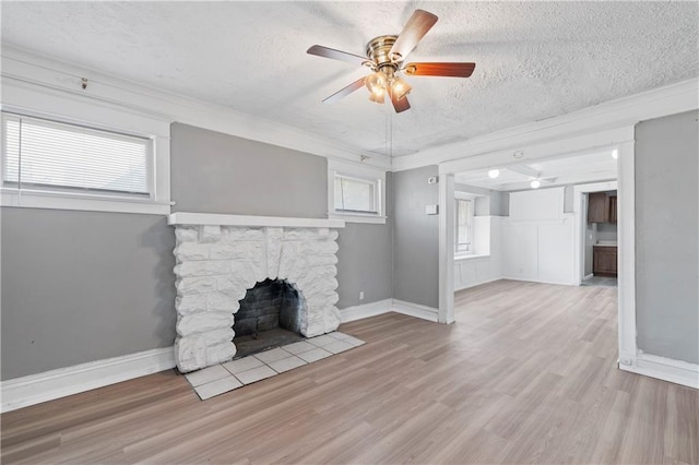 3544 College Ave, Kansas City, MO 64128 - unfurnished living room with a textured ceiling, a fireplace, ceiling fan, wood finished floors, and ornamental molding