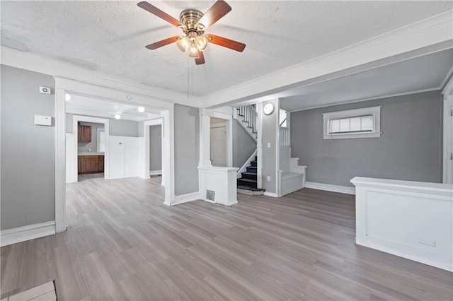 3544 College Ave, Kansas City, MO 64128 - below grade area featuring a textured ceiling, ceiling fan, wood finished floors, stairs, and crown molding