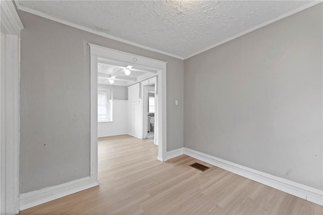 3544 College Ave, Kansas City, MO 64128 - spare room featuring wood finished floors, a textured ceiling, and ornamental molding