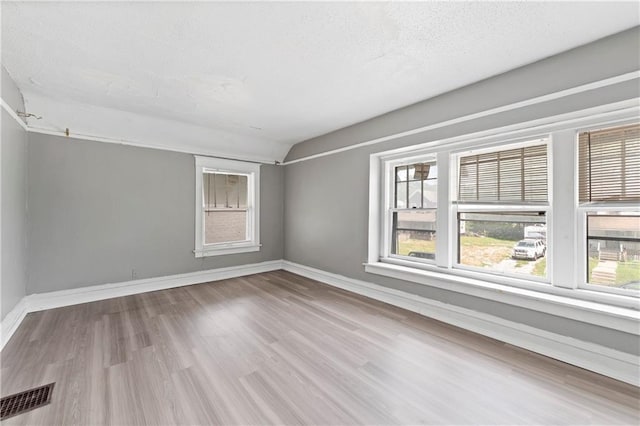 3544 College Ave, Kansas City, MO 64128 - spare room featuring wood finished floors and vaulted ceiling