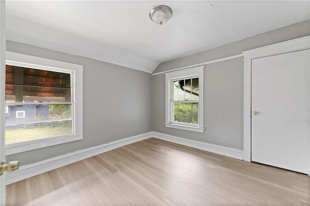 3544 College Ave, Kansas City, MO 64128 - spare room featuring vaulted ceiling and wood finished floors